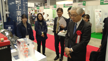 出展企業を視察する中小機構の宮川正理事長の写真画像