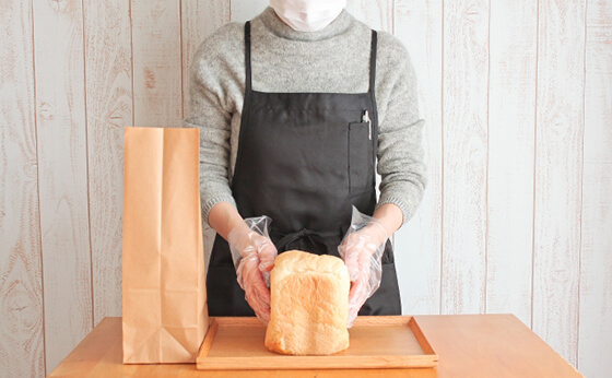 パンを袋詰めする女性